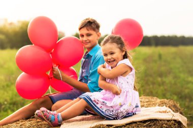 kız ve erkek kardeşim yaz aylarında doğa kırmızı balon ile oynamak