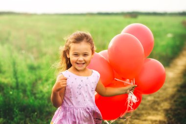 kız yaz aylarında doğa kırmızı balon ile çalışır