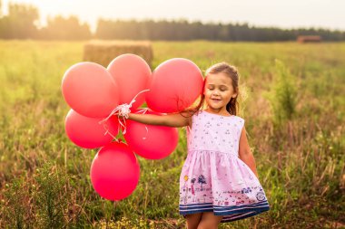 kız yaz aylarında doğa kırmızı balon ile çalışır
