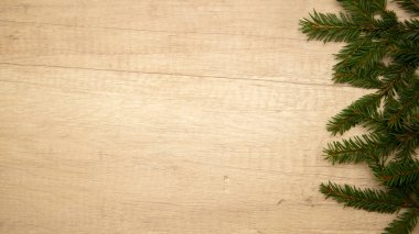 Noel kompozisyonu. Hafif ahşap arka planda köknar dalları. Çerçeve. Düz yatıyordu. Üst görünüm ve kopyalama alanı.