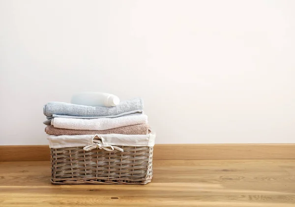 Wicker laundry basket with folded bath towels and washing gel