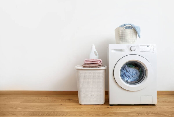 Washing machine, washing gel and laundry baskets on white background