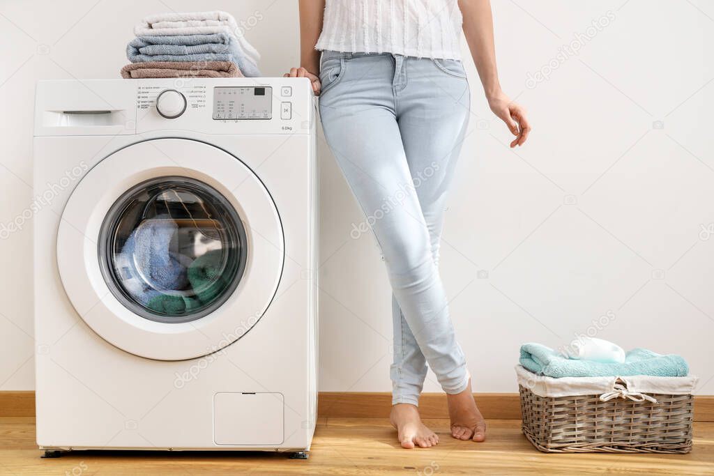 Young woman near washing machine