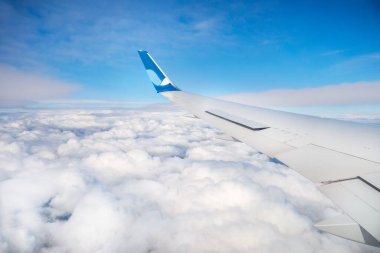 Mavi gökyüzünde bulutlu uçak kanadı
