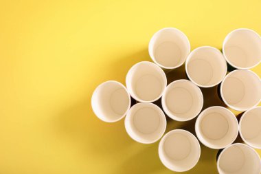 Sarı arka planda birçok tek kullanımlık gözlük, üst görünüm