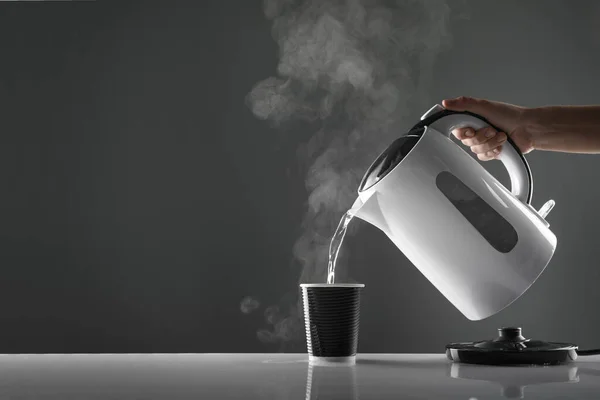 Electric White Kettle Pouring Water Cup Table Grey Background — Stock Photo, Image