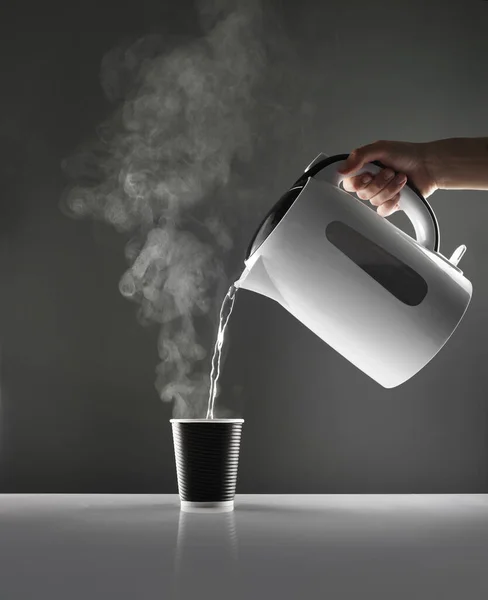 Electric White Kettle Pouring Water Cup Table Grey Background — Stock Photo, Image