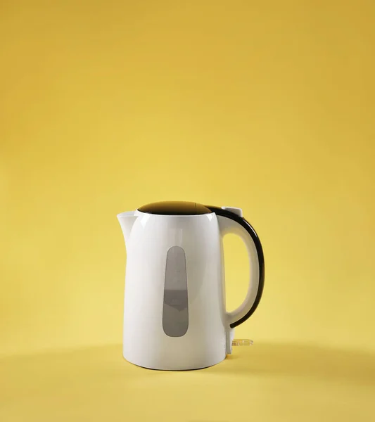 Hervidor eléctrico blanco sobre mesa sobre fondo amarillo — Foto de Stock