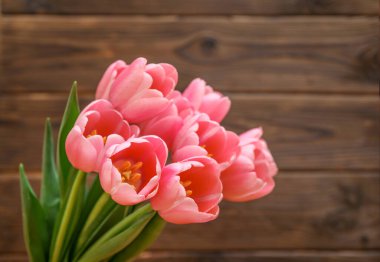 Ahşap arka planda pembe laleler