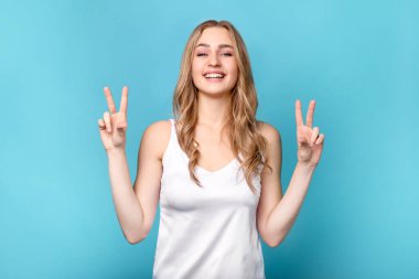 Güzel bir kadın mavi arka planda teneke gösteriyor