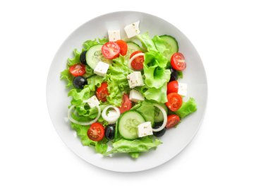 Beyaz arka planda izole edilmiş beyaz tabakta geleneksel Yunan salatası.