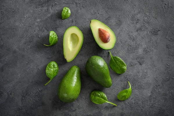 Hele Gehalveerde Avocado Vruchten Donkere Achtergrond Bovenaanzicht — Stockfoto