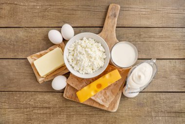 Çeşitli süt ürünleri ve ahşap arka planda çiğ yumurta. Üst görünüm.