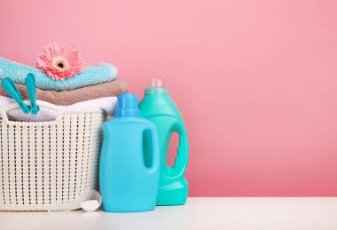 Pembe duvarda çamaşır deterjanı ve havlu var.