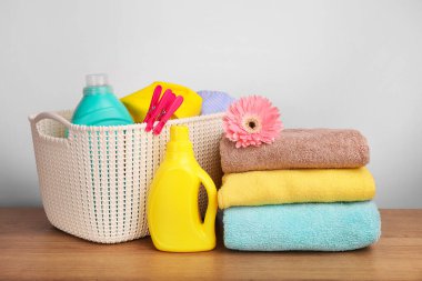 Deterjan, beyaz duvarda çamaşır tozu ve havlu.