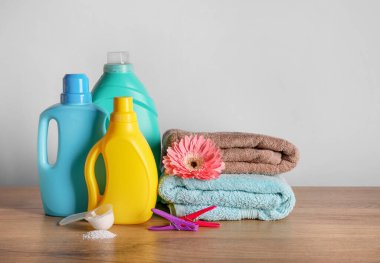 Deterjan, beyaz duvarda çamaşır tozu ve havlu.