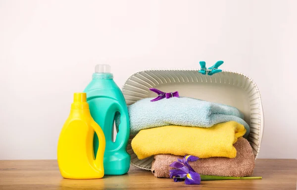 Detergent with washing powder and towels over white wall