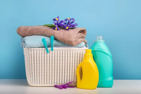 Detergent with washing powder and towels over blue wall