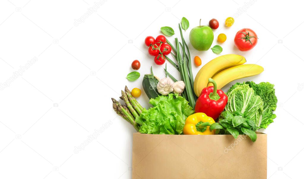 Paper bag full of different healthy food isolated on white background. Top view.