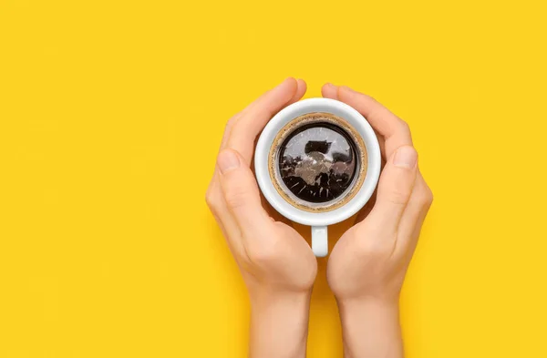 Manos Sosteniendo Taza Con Café Negro Caliente Sobre Fondo Amarillo — Foto de Stock