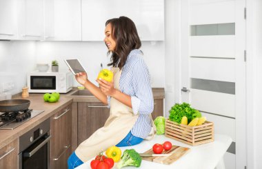 Genç Afrikalı kadın mutfakta yemek pişiriyor. Evde yemek pişirmek. Sağlıklı yiyecekler. Diyet kavramı.