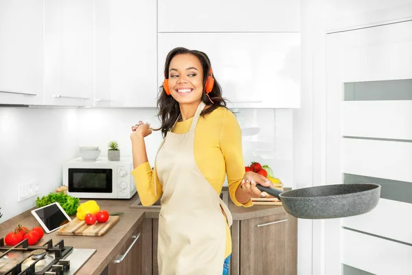 Young african woman cooking in kitchen. Cooking at home. Healthy food. Dieting concept.