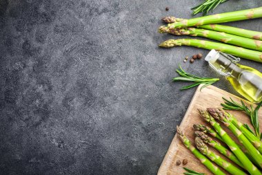 Taze kuşkonmaz ve siyah arka planda kuşkonmaz yağı. Üst Manzara. Boşluğu kopyala.