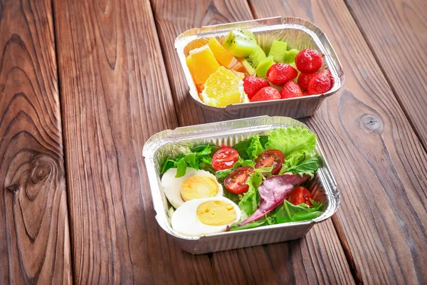 Restaurant healthy food delivery in take away boxes on wooden background.