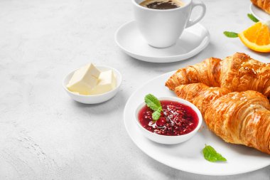 Taze kruvasan, sade kahve ve beyaz arka planda reçel..