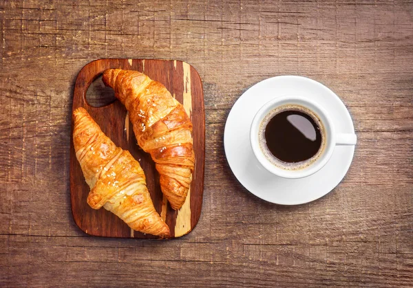Verse Croissants Zwarte Koffie Houten Ondergrond Bovenaanzicht — Stockfoto