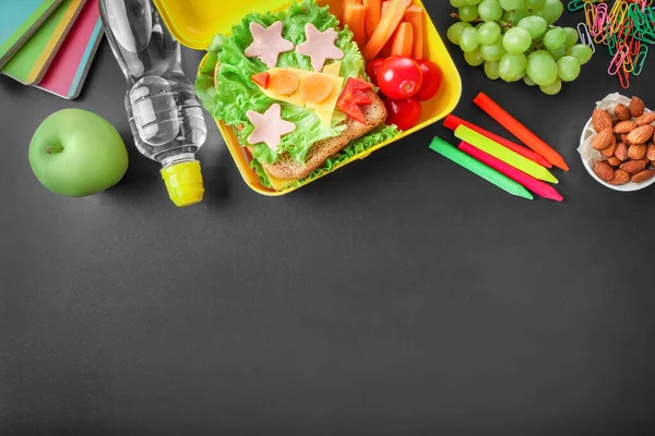 健康的学校午餐盒和黑色背景的学校文具 顶部视图 复制空间 — 图库照片