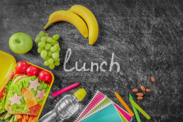 健康的学校午餐盒和黑色黑板背景的学校文具 顶部视图 复制空间 — 图库照片