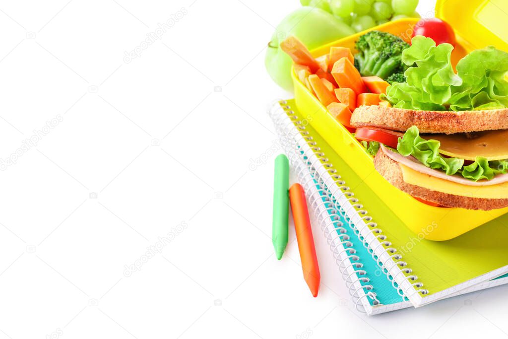 Healthy school lunch box and school stationery isolated on white background.