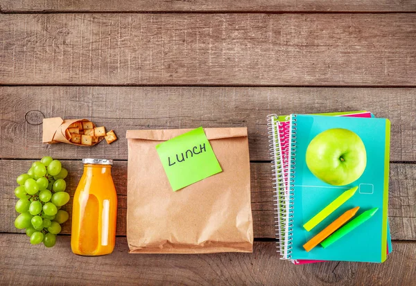 纸袋与午餐和学校文具木制背景 顶部视图 复制空间 — 图库照片