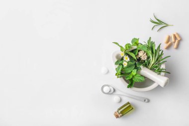 Havan topuzunda tıbbi bitkiler, cam şişede organik aroma yağı ve beyaz arka planda izole edilmiş bitkisel haplar. Üst Manzara. Uzayı kopyala Bitkisel tıp konsepti.