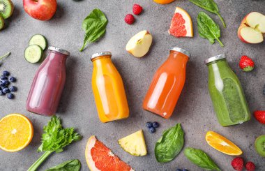 Taş zeminde cam şişelerde meyve suyu seti. Üst görünüm.