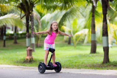 Vurgulu kurulu çocuk. Çocuklar yaz Park sürme. Çocuklar için denge kurulu. Elektrik kendini şehir sokak motorla Dengeleme. Kız Hoverboard binmek için öğrenme. Okul çocuk için modern araçlar.