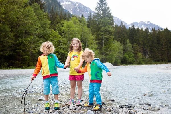 在阿尔卑斯山横渡河的孩子徒步旅行 在奥地利 孩子们在山上玩水 春天的家庭假期 小男孩和女孩在远足小径 户外娱乐 儿童活动娱乐 — 图库照片