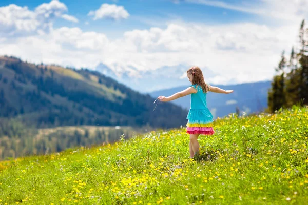 アルプスの山々で子供たちのハイキング 子供たちはオーストリアの雪に覆われた山を見てください 春休み 高山草原に咲くハイキングコースの少女 アウトドアの楽しさと健康的な活動 — ストック写真