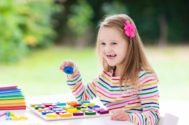 Çocuk okulda beyaz Resepsiyon için ödev. Ahşap eğitici abc oyuncak çocuklar için bulmaca. Geri okul öğrenci için çok mutluyum. Çocuk alfabesi harfleri öğrenme. Okul malzemeleri ve kitap ile küçük kız.