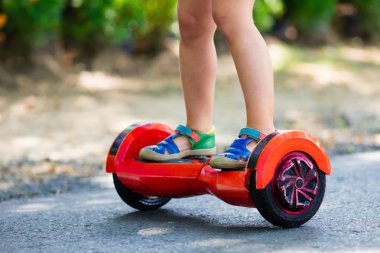 Vurgulu kurulu çocuk. Çocuklar yaz Park sürme. Çocuklar için denge kurulu. Elektrik kendini şehir sokak motorla Dengeleme. Kız Hoverboard binmek için öğrenme. Okul çocuk için modern araçlar.