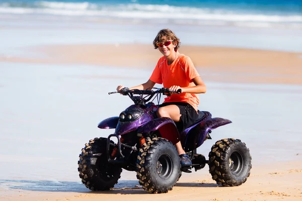 熱帯のビーチにティーンエイ ジャー乗ってクワッド自転車 四輪車のアクティブな十代の年齢の少年 全地形車両に乗る モーター クロス スポーツ海砂丘 ロードレース海岸します 夏の休暇の活動 — ストック写真