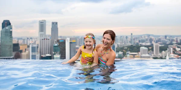 在新加坡 孩子们在屋顶上的室外游泳池游泳 享受家庭度假 城市天际线从豪华酒店的无限游泳池 在亚洲 孩子们一边游泳一边欣赏摩天大楼的美景 与幼儿一起旅行 — 图库照片