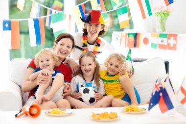 Televizyonda futbol maçı izlerken çocuklu aile. Grup Genç yetişkinler ve çocuklar Ulusal Triko izle futbol maçı televizyonda. Tezahürat ve ülke Takım Şampiyonası'nda destekleyen hayranları.