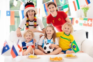 Televizyonda futbol maçı izlerken çocuklu aile. Grup Genç yetişkinler ve çocuklar Ulusal Triko izle futbol maçı televizyonda. Tezahürat ve ülke Takım Şampiyonası'nda destekleyen hayranları.