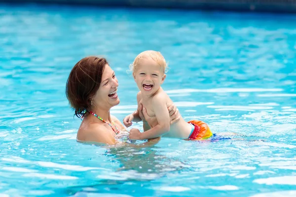 熱帯リゾートの屋外スイミングプールでの母親と赤ちゃん 子供は泳ぐことを学ぶ 母親と子供が水で遊んでいる エキゾチックな目的地で家族の夏休み 子供のためのアクティブで健康的なスポーツ — ストック写真