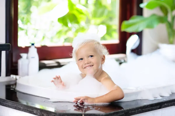 小孩子在美丽的浴室与大花园景观窗口泡浴 孩子们的卫生洗发水 头发治疗和肥皂的儿童 小孩在大浴缸里洗澡头发泡沫的婴孩男孩 — 图库照片