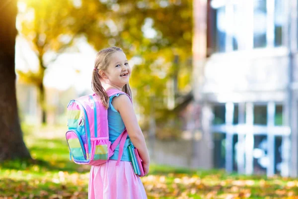Çocuk okula geri dönüyor. Yaz tatilinden sonraki yıl yeni bir okula başlıyorum. İlk okul gününde sırt çantası ve kitapları olan küçük bir kız. Dersin başında. Anaokulu ve anaokulu çocukları için eğitim.