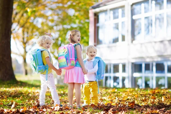 Çocuklar okula geri döner. Yaz tatilinden sonraki yıl yeni bir okula başlıyorum. İlk okul gününde sırt çantası ve kitapları olan kız ve erkek. Dersin başında. Anaokulu ve anaokulu çocukları için eğitim.