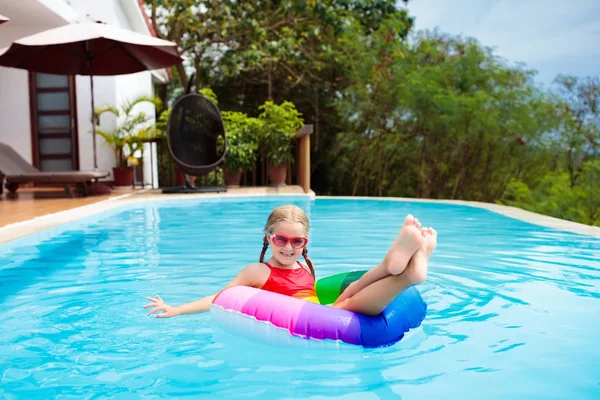 スイミング プールでゴーグルの子 小さな女の子が泳ぐし トロピカル リゾートの屋外プールでダイビングを学ぶします 子供たちと一緒に泳ぐ 子供のための健康的なスポーツ活動 太陽の保護 水の楽しみ — ストック写真